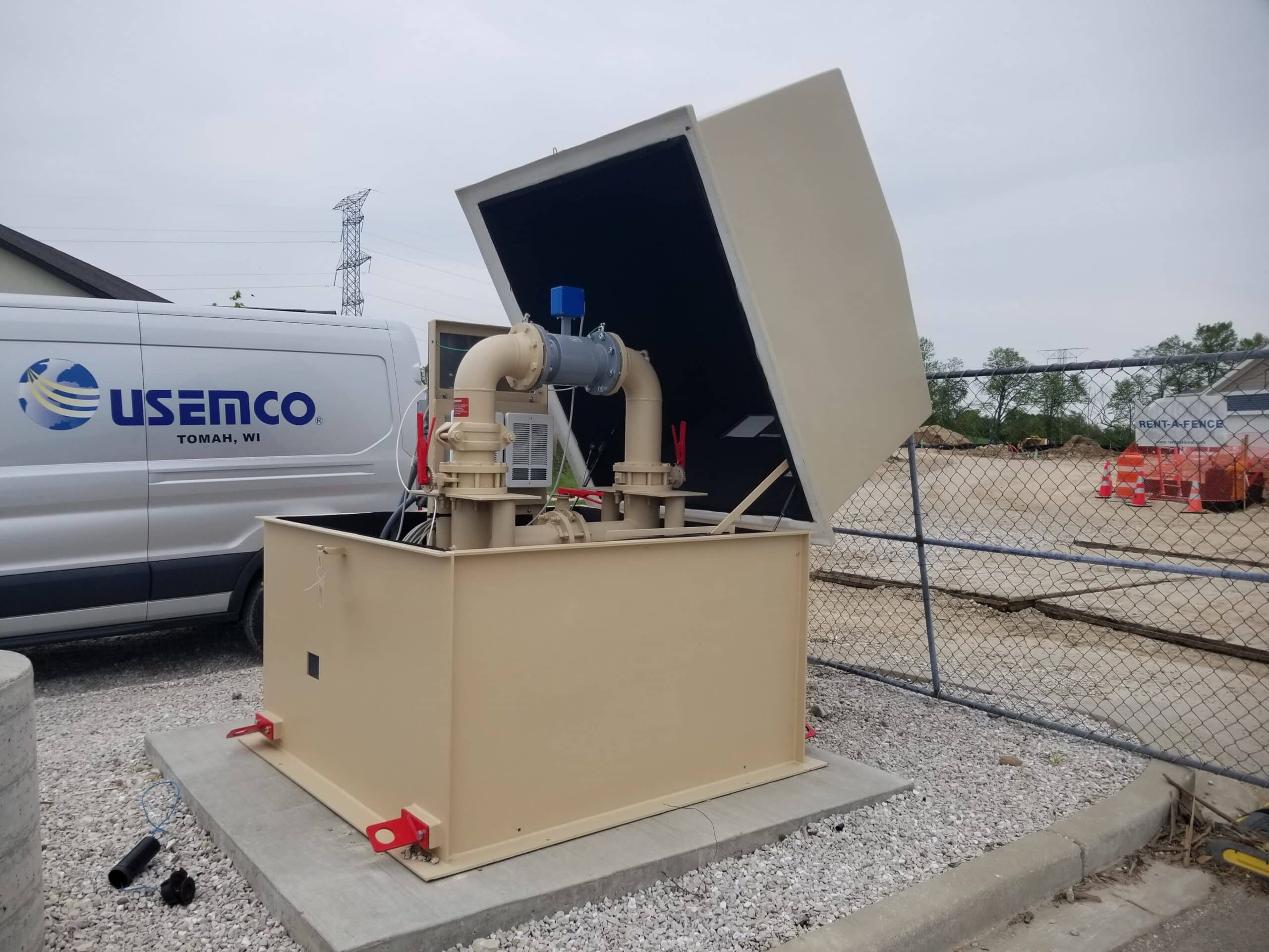 USEMCO MiniPak USEMCO MiniPak booster installed at the job site. Has the flip top cover opened showing the inside components of controls, piping, etc.