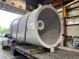 Cylindrical Sump Tank loaded on truck for delivery.