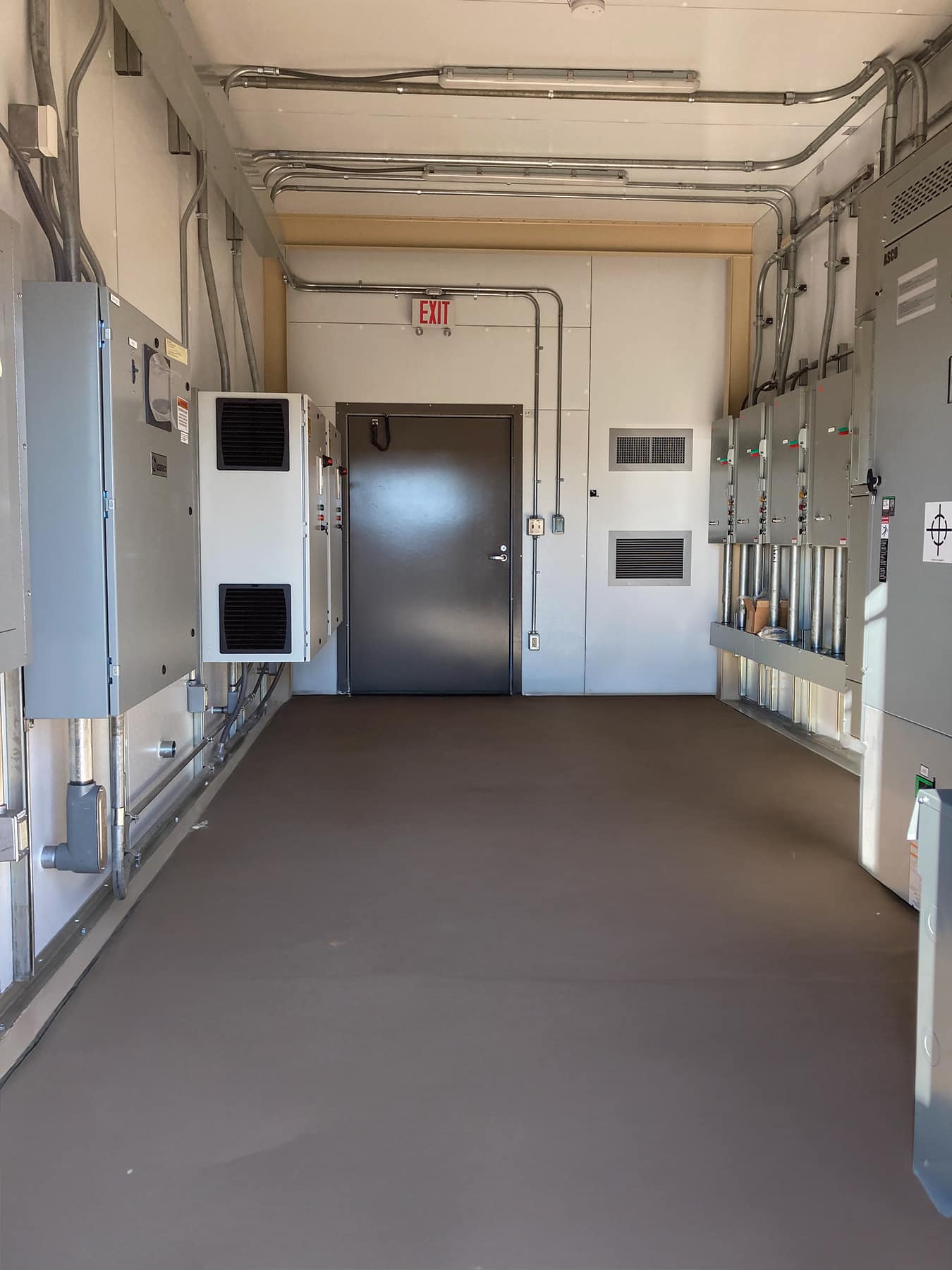 Power Shack Interior Interior picture of Power Shack building. Shows control panels on each side with exit door at end wall.